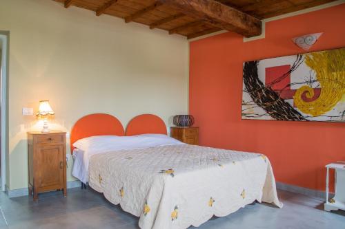 a bedroom with a bed and a painting on the wall at B&B Ai Prati in Monestirolo