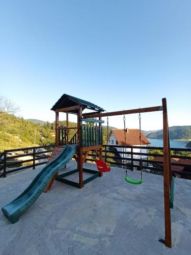a playground with a slide and a swing set at Villa Montana Zaovine in Bajina Bašta