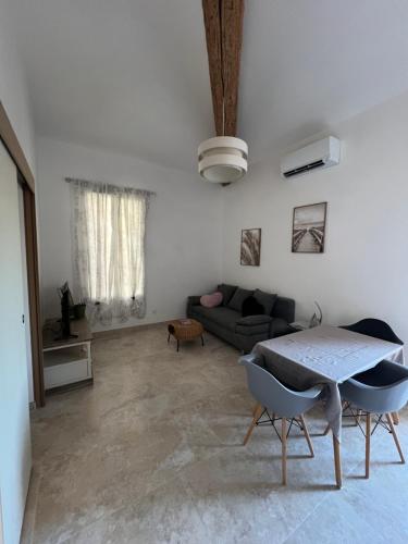 un salon avec un canapé et une table dans l'établissement Les hirondelles du soleil, à Poussan