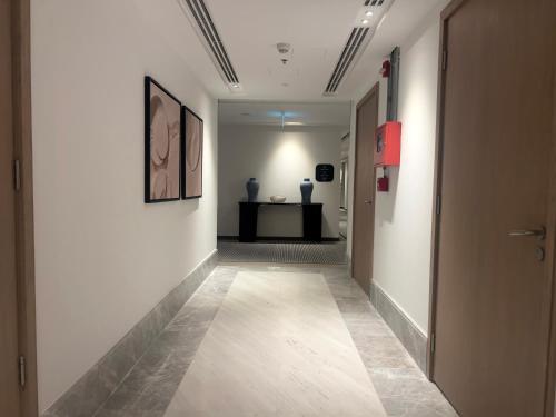 a hallway with white walls and a tile floor at Marassi, Luxury Suite in Address Beach resort! service apartment in El Alamein