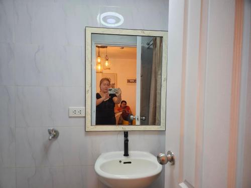 eine Person, die ein Bild in einem Badezimmerspiegel macht in der Unterkunft Mika's Crib 2BR condo in Dumaguete