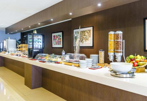 a buffet line with plates and bowls of food at B&B HOTEL Saint-Avold Nord in Saint-Avold