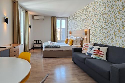 a bedroom with a bed and a couch in a room at Aparthotel AMMI Nice Massena - ex Ajoupa in Nice