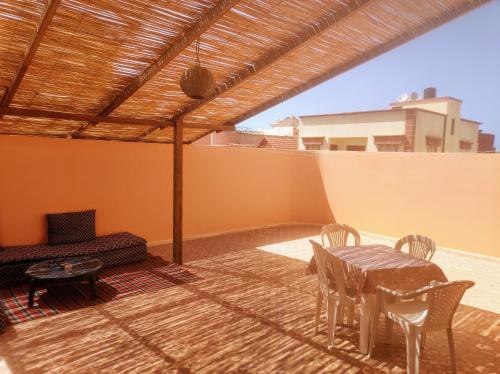 a patio with a table and chairs and a couch at Dar Pikhasa in Saidia 