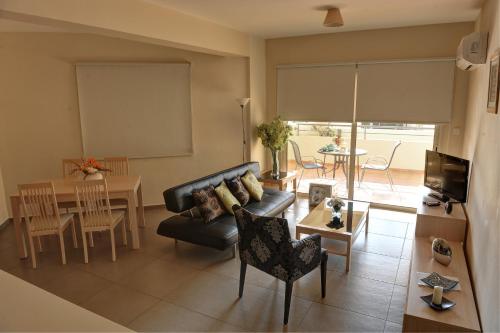 a living room with a couch and a table at Aphrodite Sands in Mandria