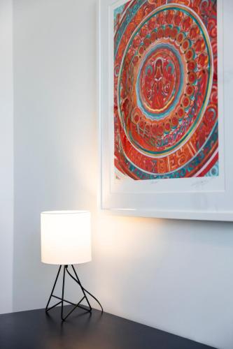 a white lamp next to a painting on a wall at American Hotel in Los Angeles