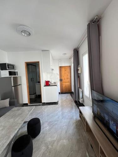 Il comprend un salon avec une télévision et une cuisine. dans l'établissement Paris 2024 Olympics 3-4 persons, à Paris