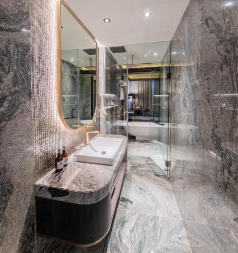 a bathroom with a sink and a mirror at Pentacity Hotel Balikpapan in Balikpapan
