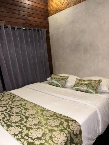a bedroom with two beds with white sheets and pillows at Pondok Genitri in Bringkit