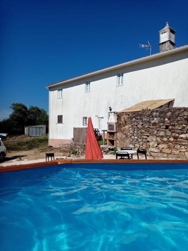 a house with a swimming pool in front of a building at O Sitio da Paz in Robalo