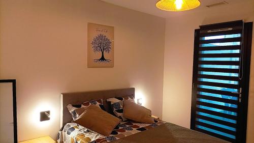 a bedroom with a bed and a tree picture on the wall at Villa Belles étoiles en Cévennes classée 3 étoiles avec piscine privée dans le Gard in Ribaute-les-Tavernes