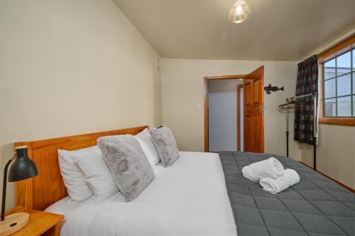 a bedroom with a large white bed with two pillows at Villa Family Friendly Classic Charm in Kaikoura