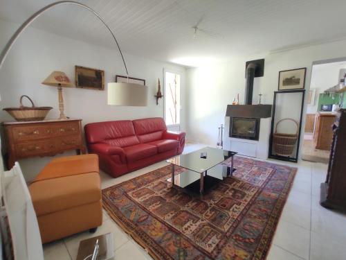 un salon avec un canapé rouge et une table dans l'établissement Maison de campagne sur 2 hectares, à Grignols