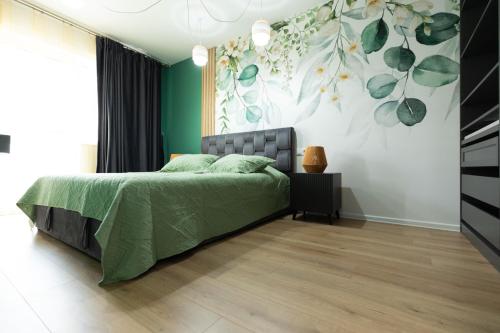 a bedroom with a bed and a green wall at Green Blooming Studio in Baia Mare