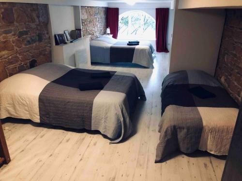 Cette chambre d'hôtel dispose de 2 lits et d'un mur en briques. dans l'établissement Superbe duplex, Pentes Croix-Rousse, Lyon 4ème, à Lyon