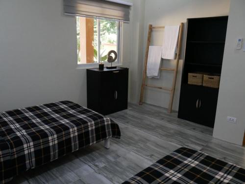 a bedroom with a bed and a window and a mirror at TLT Guesthouses - Dauin in Dauin