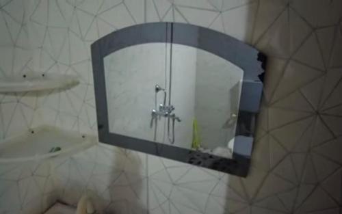 a mirror on a wall in a bathroom at Amar Bari Happy Valley Cottages by StayApart in Mangpu