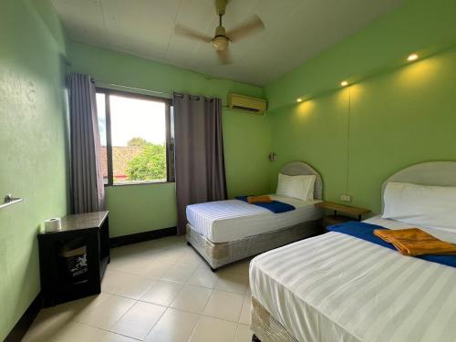 a bedroom with two beds and a window at Bella Bella House in Bangkok
