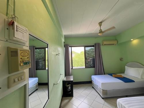a small room with two beds and a window at Bella Bella House in Bangkok