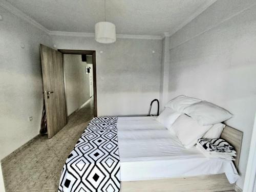 a bedroom with a bed with white sheets and pillows at SOLI Apartment in Neoi Epivates