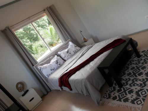a bedroom with a bed with a large window at TLT Guesthouses - Dauin in Dauin