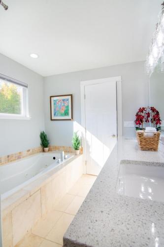 a white bathroom with a tub and a sink at Private Family Home With Gorgeous Yard in Camas
