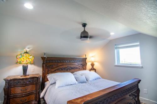 a bedroom with a bed and a lamp and a window at Private Family Home With Gorgeous Yard in Camas