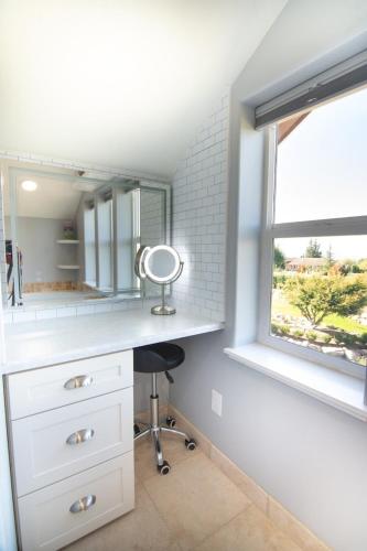 a bathroom with a vanity with a mirror and a window at Private Family Home With Gorgeous Yard in Camas