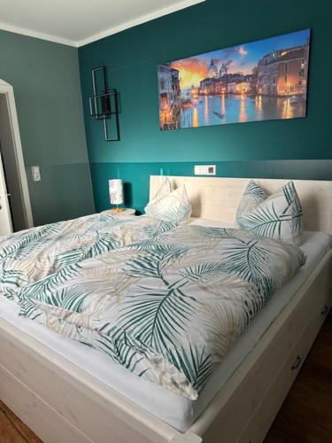 a bed in a bedroom with a painting on the wall at Pension Victoria Halberstadt in Halberstadt