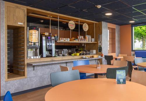 un restaurante de comida rápida con mesas y mostrador en B&B HOTEL Châteauroux A20 L'Occitane, en Déols