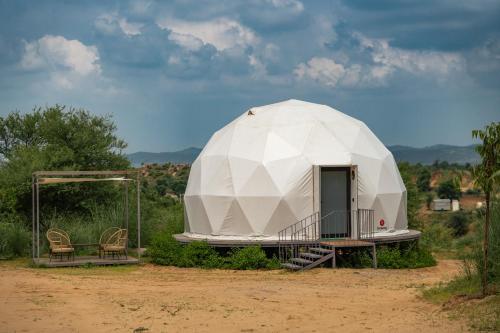 a large dome tent with a porch in a field at Teela- The Glamping Resort, Jaipur in Udāsar