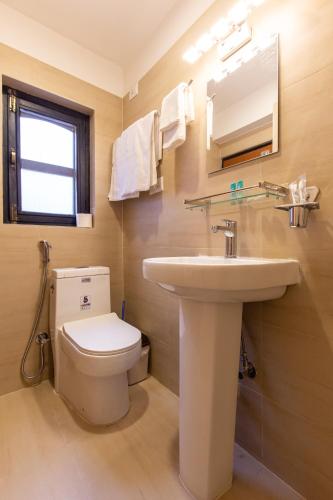 a bathroom with a white toilet and a sink at vajra house in Pātan