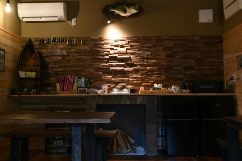 a bar in a restaurant with a stone wall at アングラーズベース下北山 in Kami-ikehara