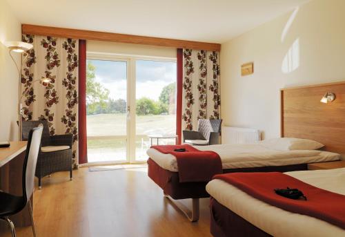 une chambre d'hôtel avec deux lits et une fenêtre dans l'établissement Araslöv Golf & Resort, à Kristianstad