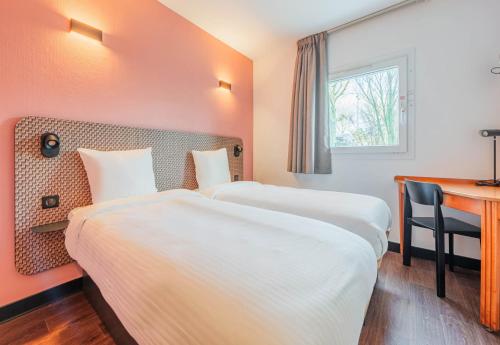 a hotel room with two beds and a desk at B&B HOTEL Strasbourg Nord Mundolsheim in Mundolsheim