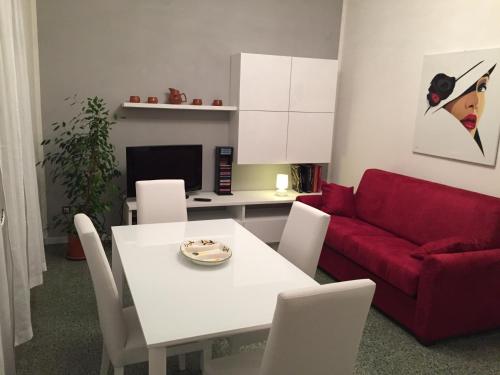 uma sala de estar com uma mesa branca e um sofá vermelho em Casa Romano em Pian del Voglio