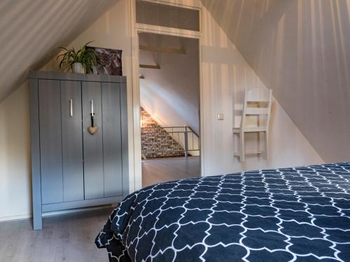 een slaapkamer met een blauw en wit bed en een trap bij Bed En Comfort in Vaassen