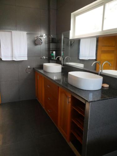 a bathroom with two sinks on a counter at TLT Guesthouses - Dauin in Dauin