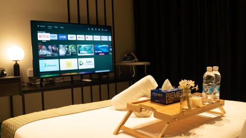 a room with a bed with a tv and a table at Axon Residence KLCC - KL HOME in Kuala Lumpur