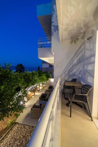 a balcony with tables and chairs on a building at Arancia Elegant Rooms and Suites in Tolo