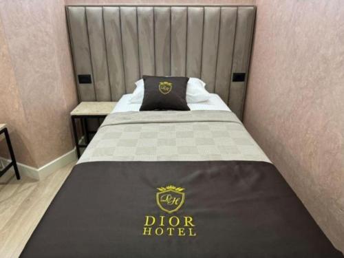a bed with a dior hotel sign on it at Hotel Dior in Krujë
