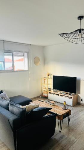 un salon avec un canapé et une table dans l'établissement Appartement Perpignan proche plage et ville, à Perpignan
