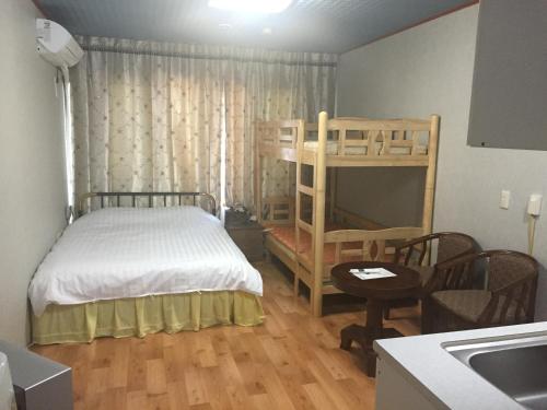 1 dormitorio con litera y cocina en Shinyang Beach Pension, en Seogwipo