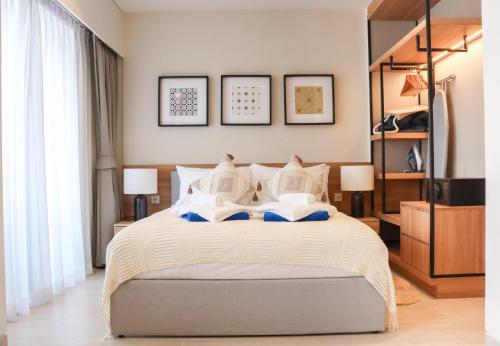 a bedroom with a bed with white sheets and pillows at Lakeside Residences by NLA in Bang Tao Beach