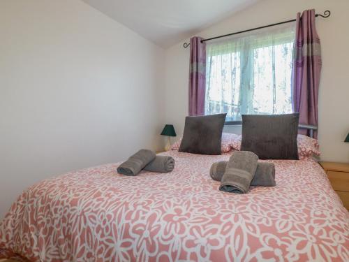 a bedroom with a large bed with two pillows at Cornish Holiday at Atlantic Bays in Saint Merryn