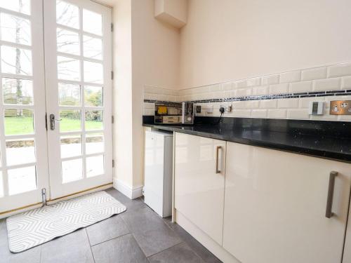 a kitchen with white cabinets and a large window at Hudson in Lancaster