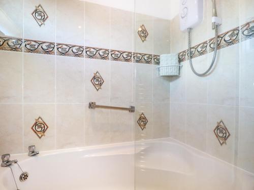 a bathroom with a tub and a shower stall at Cornish Holiday at Atlantic Bays in Saint Merryn