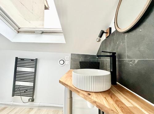 une salle de bain avec un lavabo et un miroir dans l'établissement Le Florissant, intime et raffiné, à Limoges