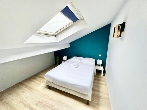 une chambre avec un lit blanc et une fenêtre dans l'établissement Le Florissant, intime et raffiné, à Limoges