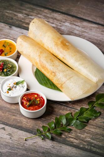 a white plate with bread on a table with dips at Lilac Kumbakonam in Kumbakonam